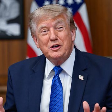 A man with blonde hair, wearing a dark suit and blue tie with an American flag pin, is speaking with his hands raised, with an American flag visible in the background. The image likely relates to the post about the U.S. response to North Korea's ballistic missile launch, suggesting he may be the official addressing the threat assessment.