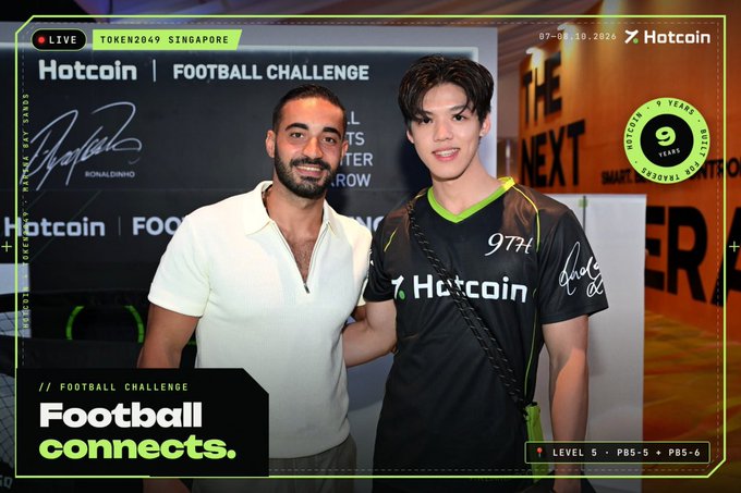 A branded football-event poster shows two men standing together, one in a white shirt and the other in a black Hotcoin jersey marked “974.” Visible text includes “Hotcoin | FOOTBALL CHALLENGE,” “LIVE,” “TOKEN2049 SINGAPORE,” “Football connects,” “9 YEARS,” and “LEVEL 5 · PBS-5 · PBS-6.”