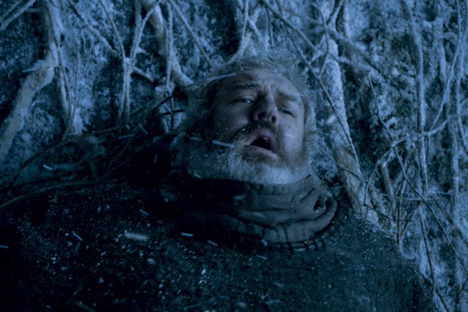 A bearded man with frosted hair lies motionless in the snow, his mouth agape and eyes closed in a final, chilling pose. The scene evokes the haunting stillness of winter's grasp, mirroring the "crypto winter" theme suggested by the accompanying post about altcoin season, where market activity has frozen just like this fallen figure.
