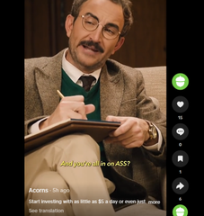 A vertical video screenshot of a man with glasses and a mustache writing in a notebook, with a caption asking 'And your milion on ASS? Acorns (5p ea) Start investing with as little as $5 a day or even just _ move See translation'.
