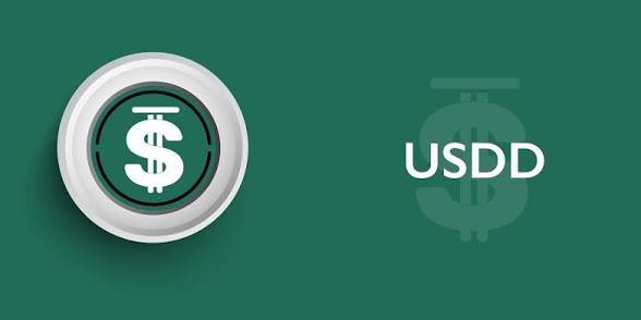 A green graphic displays a 3D-rendered coin featuring a dollar sign alongside the text "USDD," with a faint USDD logo watermark in the background, visually representing the stablecoin discussed in the post about its recent $10 million market cap growth.