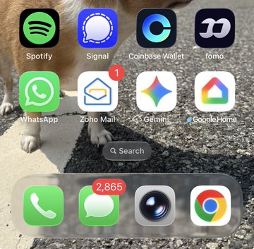 A smartphone home screen displays apps including Spotify, Signal, Coinbase Wallet (highlighted in the post), WhatsApp, Zoho Mail, Gemini, Google Home, Phone, Messages (2,865 notifications), Camera, and Chrome, set against a background photo of a dog's paws on pavement—relating to the post about Coinbase Wallet rebranding back from Base App and a referral link to support feeding dogs and cats.