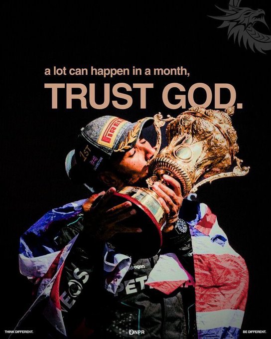 A racing driver wearing a 'PIRELLI' cap kisses a golden trophy while wrapped in a British flag, with the text 'a lot can happen in a month, TRUST GOD.' above.