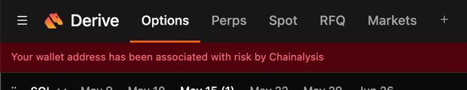 A Derive platform interface displaying a red warning banner stating "Your wallet address has been associated with risk by Chainanlysis," with navigation tabs for Options, Perps, Spot, RFQ, and Markets visible. The image illustrates the poster's experience of being flagged by Chainalysis on the Derive options trading platform, highlighting potential risks users may face despite the platform's growing popularity and DRV token appreciation.