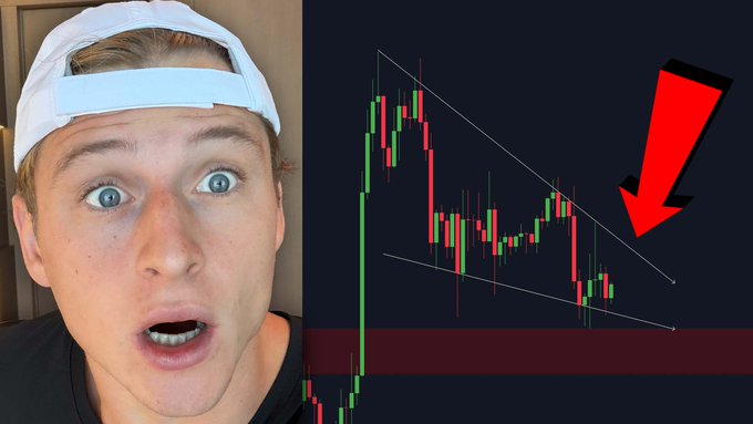 A close-up of a young man with a shocked expression wearing a light blue backward cap appears alongside a candlestick chart showing a downward price movement within a descending channel, highlighted by a large red arrow pointing down. The image serves as a thumbnail for a YouTube video warning about an imminent significant Bitcoin price move.