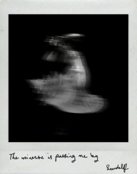 An artistic Polaroid-style photo shows a motion-blurred figure against a black background, with the handwritten caption 'The universe is passing me by' signed 'Beerdolf' at the bottom.