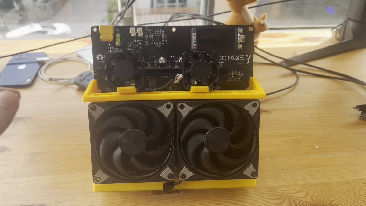 A black computer case with a yellow cooling fan sitting on top of it. The case has two fans, one at each side. There are also cables attached to both the front and back sides of this computer case. It's an interesting setup related to Bitcoin mining power and virtual reality gaming equipment.
