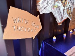 The image features a sign that reads "Write Your Thought" with an arrow pointing towards it, accompanied by a blue tablecloth and candles. The sign is located near a door or entrance, possibly at a gathering or event where people can leave messages for each other on the rice paper. The post also includes information about a collaborative triptych inspired by Bosch's Garden of Earthly Delights, which encourages visitors to leave their thoughts on rice paper and share them with others.