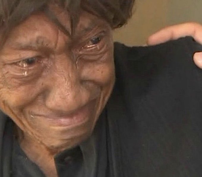 A close-up photo of an older man with tears in his eyes and a sad expression, while a hand rests comfortingly on his shoulder.