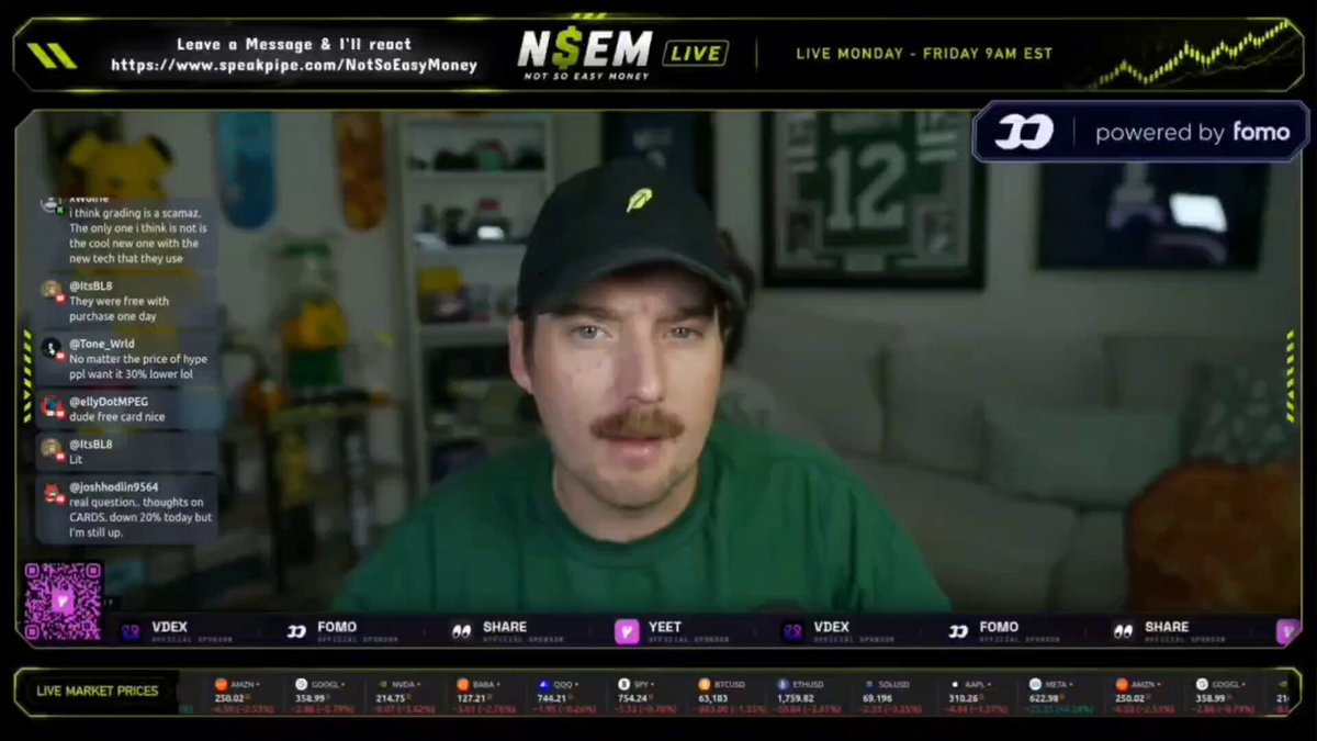 The image shows a man wearing a green shirt sitting in front of a computer screen, which displays a chat window with a message from another person named "Vita". The chat window contains several emojis, including a heart and a smiley face, as well as some text that reads "Easy reveals why $CARDS and $TCG will continue to pump when the whole market's pulling back, it's a time and place to find something of strength, and that to me is where $CARDS come in." The man appears to be engaged in a conversation with Vita.