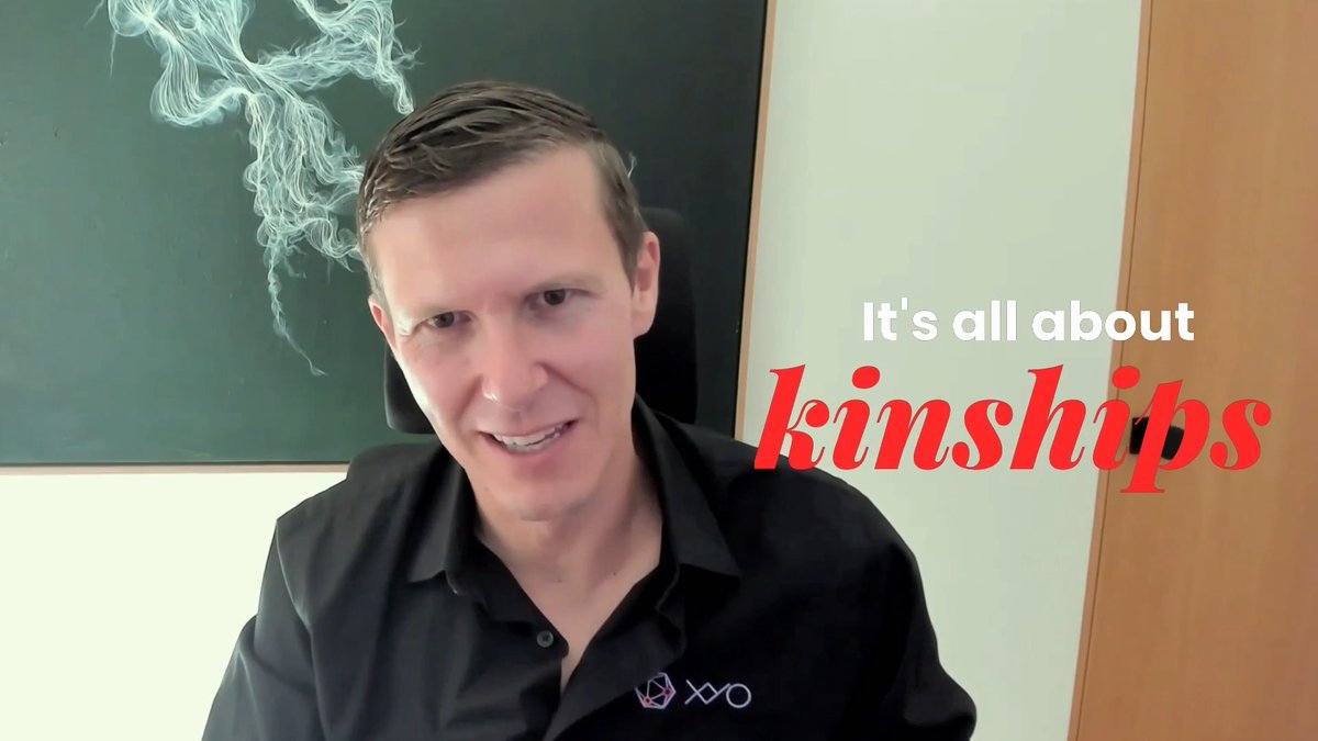A smiling man in a black XYO-branded polo shirt sits in front of a chalkboard with the text "It's all about kinships" overlaid in white and red. The image supports the post's message about the importance of relationships and trust in business.