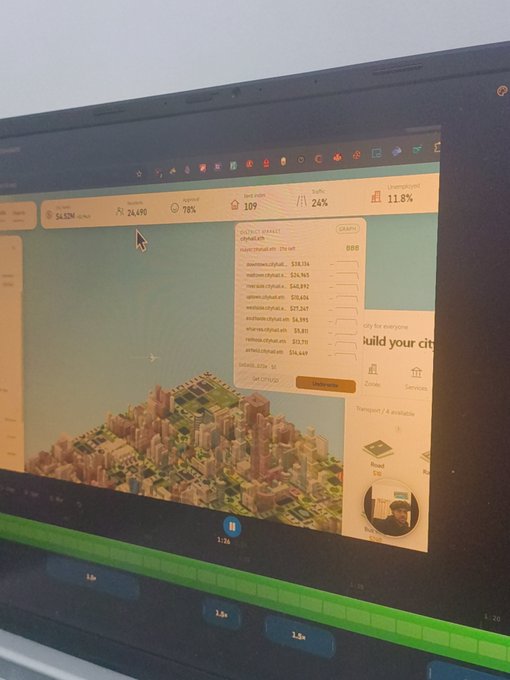 A computer monitor displays a city-building simulation game with an orange-tinted interface, showing various statistics like land value '109' and traffic '24%'. A detailed 'OUTPUT DETAILS' panel is open, listing domain rankings and a 'GRAND TOTAL' of $47,070.