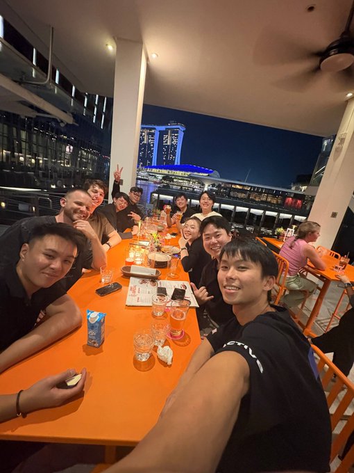 The image shows a group of people sitting around an orange dining table, enjoying each other's company. There are at least ten individuals present, with some seated while others stand or sit on chairs surrounding the table. The scene appears to be set outdoors, possibly in a restaurant or a similar venue. A few cups and wine glasses can also be seen on the table, indicating that they might be having drinks together.

The post features an image of the group posing for a picture with their cell phones held up at various angles. This suggests that they are capturing memories from their time spent together during the founders residency event. The overall atmosphere seems to be one of camaraderie and celebration, as everyone appears to be having a good time in each other's company.
