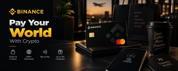 A Binance promotional banner titled "Pay Your World With Crypto" features a black Binance Mastercard alongside a phone displaying "Pay With Crypto," a coffee cup reading "Same Coffee More Freedom," and a "Travel More" card, set against a city skyline backdrop. The image visually reinforces the post's message about Binance Card transforming eligible crypto balances into practical, everyday spending power rather than just a buy-and-hold asset.