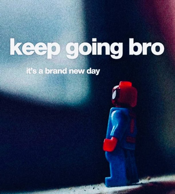 A small Lego-style figure in blue and red stands in dramatic light, with the motivational text 'keep going bro - it's a brand new day' displayed prominently.