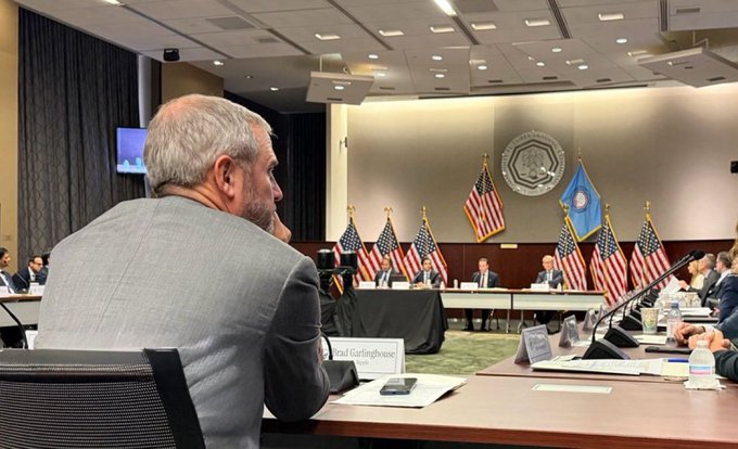 Brad Garlinghouse, CEO of Ripple, attends a roundtable discussion at the CFTC headquarters in Washington, D.C., featuring American flags and official seals in the background, aligning with his recent remarks about the U.S. being closer than ever to establishing clear crypto regulations.