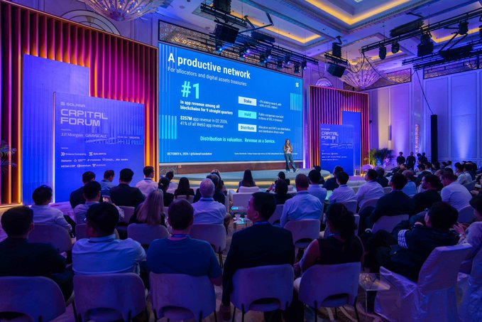 A speaker addresses an audience of approximately 150 attendees at the Solana Capital Forum in Singapore, with a presentation slide titled "A productive network for allocators and digital assets treasury" displayed prominently on the large screen behind them.
