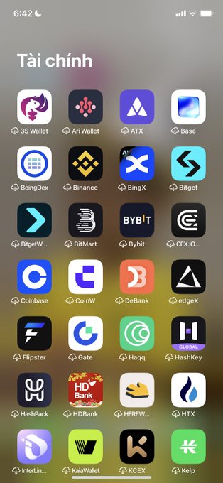 An iPhone home screen showing a folder titled 'Tài chính' (Finance) containing numerous cryptocurrency wallet and exchange app icons including Binance, Bybit, Coinbase, and others.