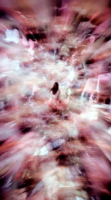 The image features a woman standing in front of a blurry background, which appears to be a pinkish-purple color. The photo has been edited or blurred, giving it an artistic and dreamy appearance. The caption below the image reads "gm and happy #tezostuesday with #BraveHeart". This suggests that the photo may have been taken on a special occasion like Tezstuesday or is related to a social media post celebrating the hashtag #Braveheart.