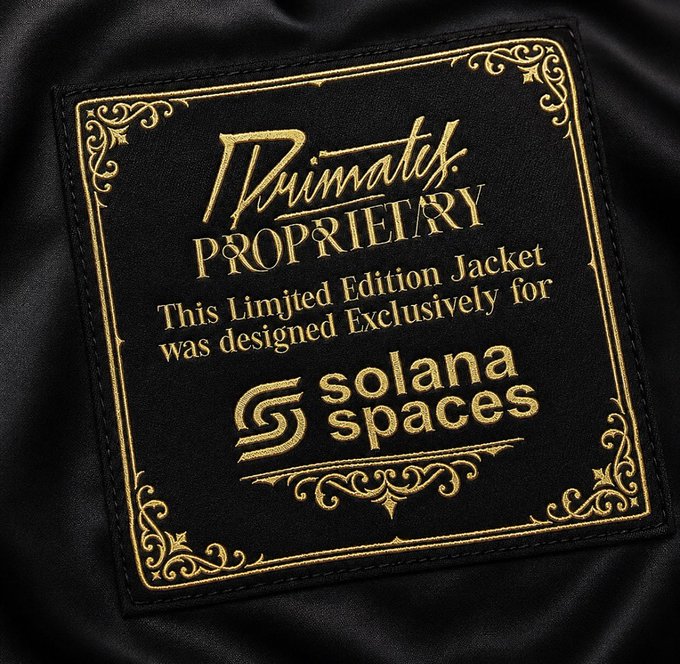 A close-up of a black satin jacket label with gold embroidered text reading "Ruimatex PROPRIETRY - This Limited Edition Jacket was designed Exclusively for Solana Spaces," featuring ornate decorative borders, referencing a custom collaboration jacket from the post.