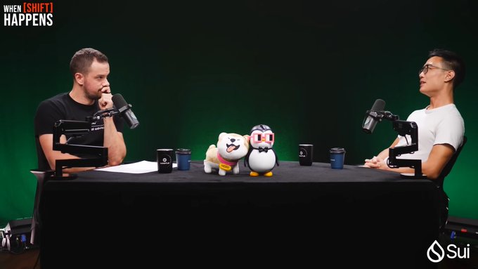 Two podcast hosts sit across from each other at a desk with microphones and plush mascots, under a "When Shift Happens" banner with a "Sui" logo, discussing HIP-4 and Hyperliquid's founder Jeff's revenue-burning approach versus Polymarket.