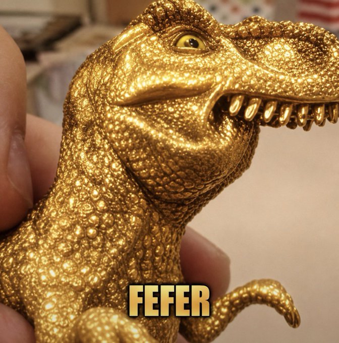 A golden dinosaur figurine with the word "FEFER" is held in someone's hand, relating to Tether Gold.
