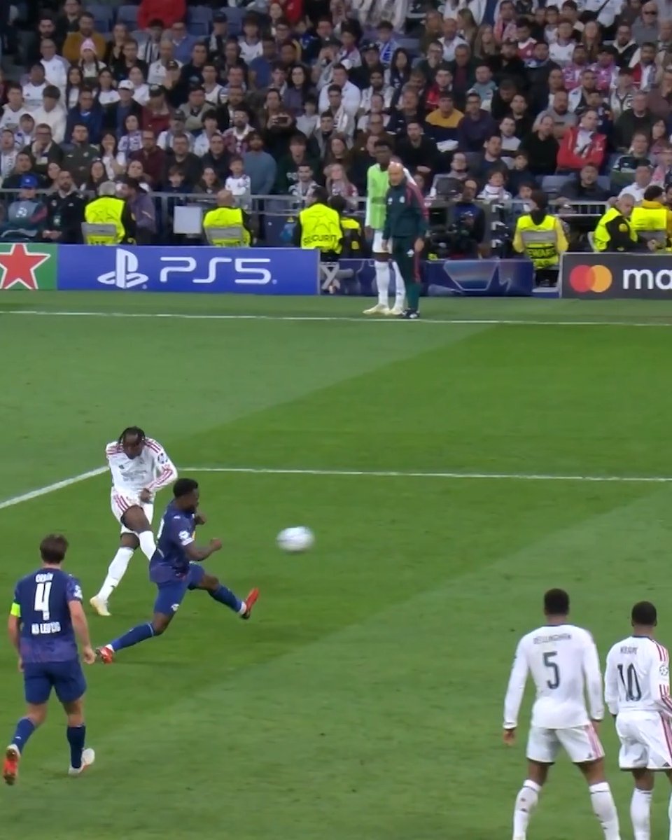 A soccer match shows a player in a dark blue kit striking the ball while teammates in white and blue kits watch; visible text includes “PS5,” “mastercard,” jersey numbers 4, 5, and 10, and “80 YEARS” on number 4. The post’s “Yan Diomande is what a $100 million player actually looks like” caption appears to highlight the attacker’s technique or ability in the action.