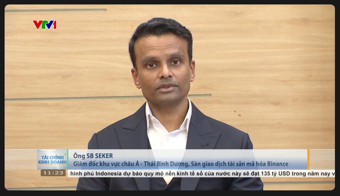 A man in a dark suit appears on VTV1's "Tài chính Kinh doanh" segment, with on-screen text identifying him as Ông SB Seker, Regional Director of Asia-Pacific (excluding India-Pacific) at Binance. The lower-third ticker references Binance and Indonesia's economy reaching $135 billion, aligning with the post about Binance's APAC director discussing strategic plans for the Vietnamese market.