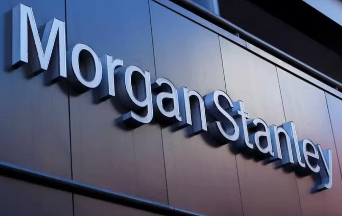 A close-up of the illuminated 'Morgan Stanley' corporate signage mounted on a building exterior.