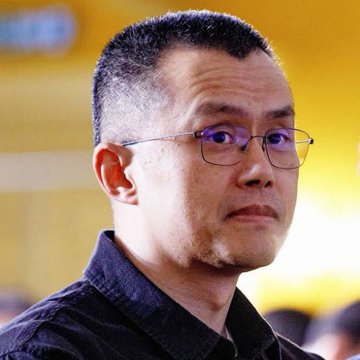 The image shows a close-up of Binance founder Changpeng Zhao (CZ), a man with short dark hair and glasses wearing a dark shirt, looking off to the side. This relates to the post as it features CZ, the Binance executive who made the bold prediction about a potential crypto supercycle in 2026.