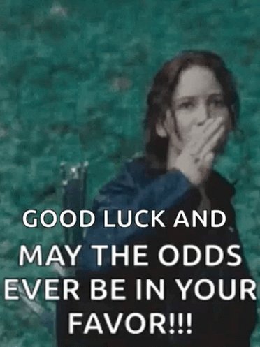 The image features a woman wearing a blue jacket, standing against a green background. She has her mouth open as if she's gasping or shouting something out loud. The caption below the photo reads "Good Luck and May the Odds be in Your Favor!".