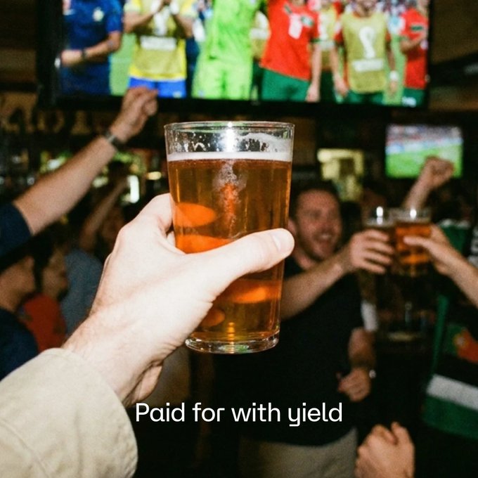 A hand raises a frosty pint of beer in a crowded sports bar where fans are cheering on a soccer match displayed on the TV overhead, while the text "Paid for with yield" appears below—imagery that playfully suggests viewers can fund their game-day drinks with crypto yield rewards from the hemiBTC/VUSD pool on Vetro and StakeDAO.