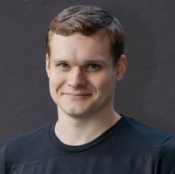 A headshot portrait of a smiling young man with reddish-brown hair, wearing a dark t-shirt against a gray background—likely depicting Illia Polosukhin, NEAR Protocol co-founder. The image accompanies news of his proposal to establish a NEAR Sovereign Fund to manage the protocol's treasury.