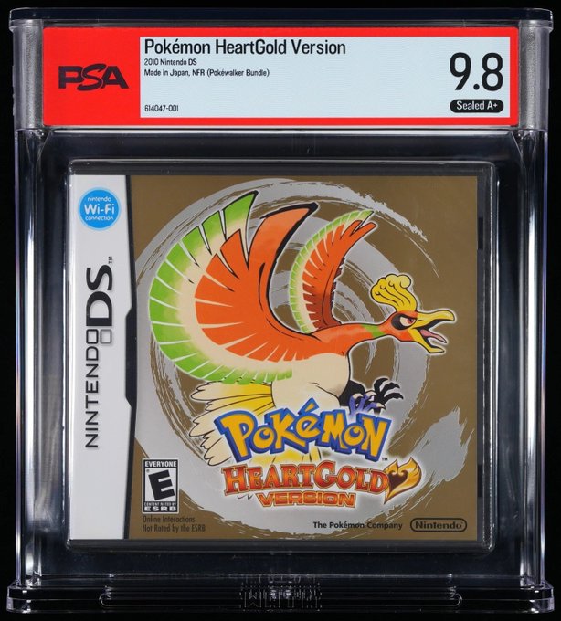 A PSA-graded 9.8 "A+" sealed copy of Pokémon HeartGold Version (Nintendo DS, NFR Pokéwalker Bundle) is displayed in its protective case, with the game's iconic Ho-Oh artwork prominently featured on the cover. This near-mint condition, factory-sealed rare game sold for $1,256, as noted in the accompanying post.