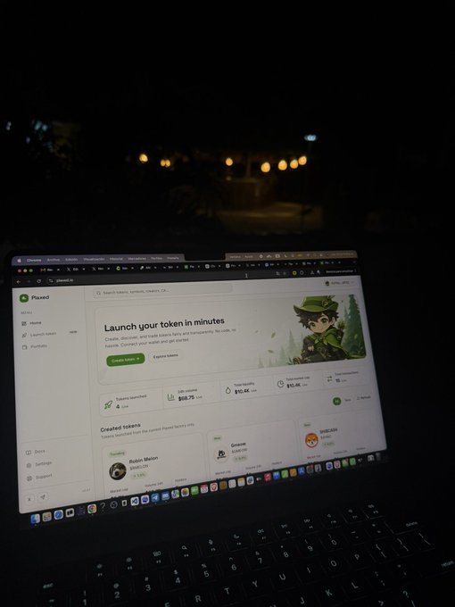 A laptop screen displays the Plaxed platform dashboard at night, showing the "Launch your token in minutes" landing page with features like "Tokens launched" (4), "Liquidity" ($58.75), and "Token liquidity" ($10.4K). The image captures a real work session during "Day 2 building" of the project, with the 3AM timestamp reflecting the early-stage hustle described in the post.