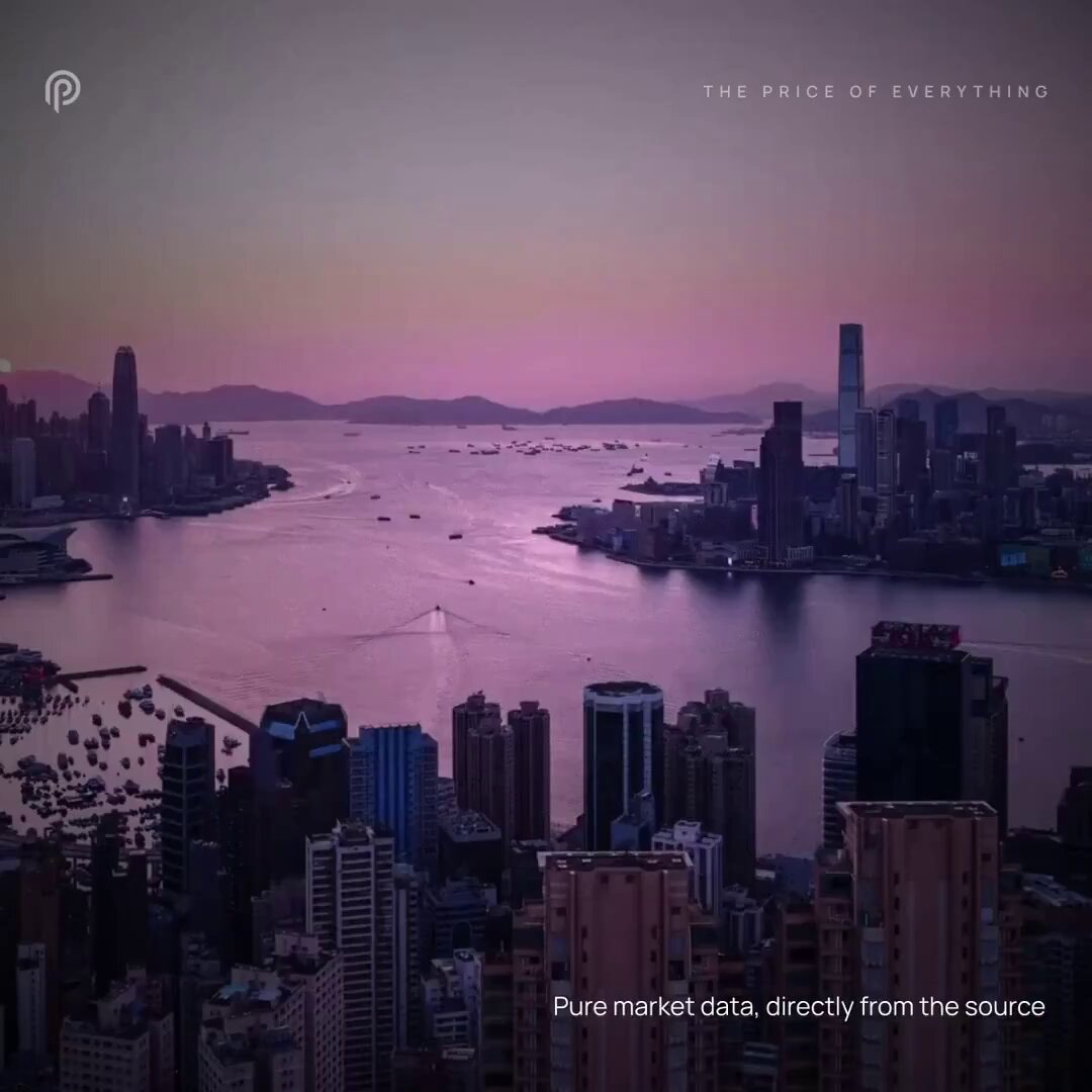 The image shows a city skyline with a large body of water, possibly an ocean or bay, in the background. The sky appears to be pinkish-orange, suggesting either sunrise or sunset. In the foreground, there are several buildings, including one that says "pure market data directly from the source". This building is likely related to Tencent and Bitcoin, as it has a connection with the cryptocurrency market.