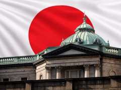 The image shows a Japanese government building with the red and white flag of Japan waving in the background, symbolizing Japan's national endorsement of financial innovation. The caption relates to the post by visually representing Japan as the country making a major move toward embracing crypto ETFs, tying the national symbol to the announcement by Japan Exchange Group CEO Hiromi Yamaji about introducing cryptocurrency ETFs.