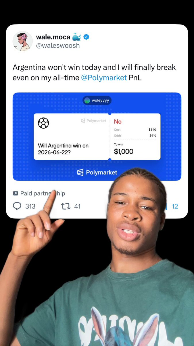 The image features a man wearing a green t-shirt with an animal design, standing next to a blue square sign that says "argentina won't win today and will finally break even on my all time @POLYMARKET." The man is pointing at the sign, drawing attention to it. The post includes text about a man's victory in a game or competition, possibly related to the Polymarket platform.