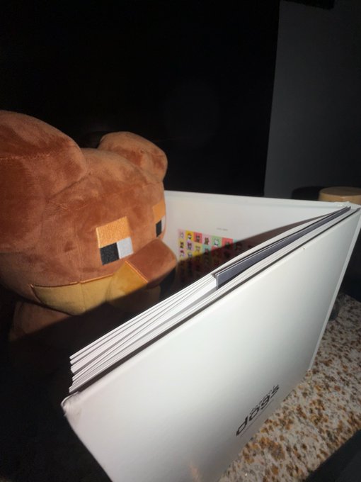 A brown plush duck toy resting on top of an Acer laptop on a granite countertop.