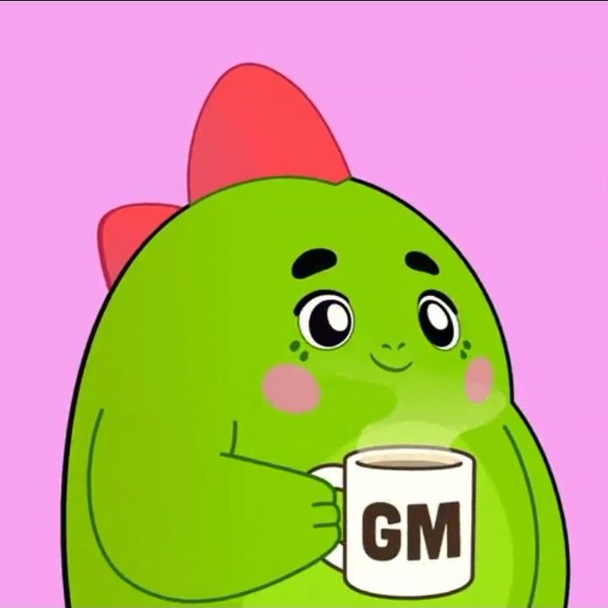 Cute green blob-like cartoon character with a red bow on a pink background, holding a white mug labeled 'GM' (a common crypto 'Good Morning' meme).