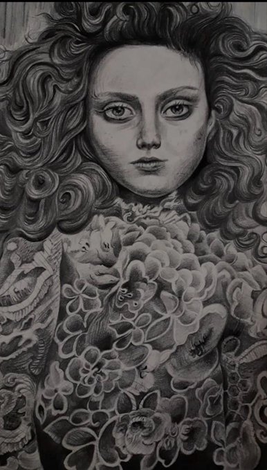 A detailed grayscale illustration portrays a woman with large curly hair wearing an intricately floral patterned garment.