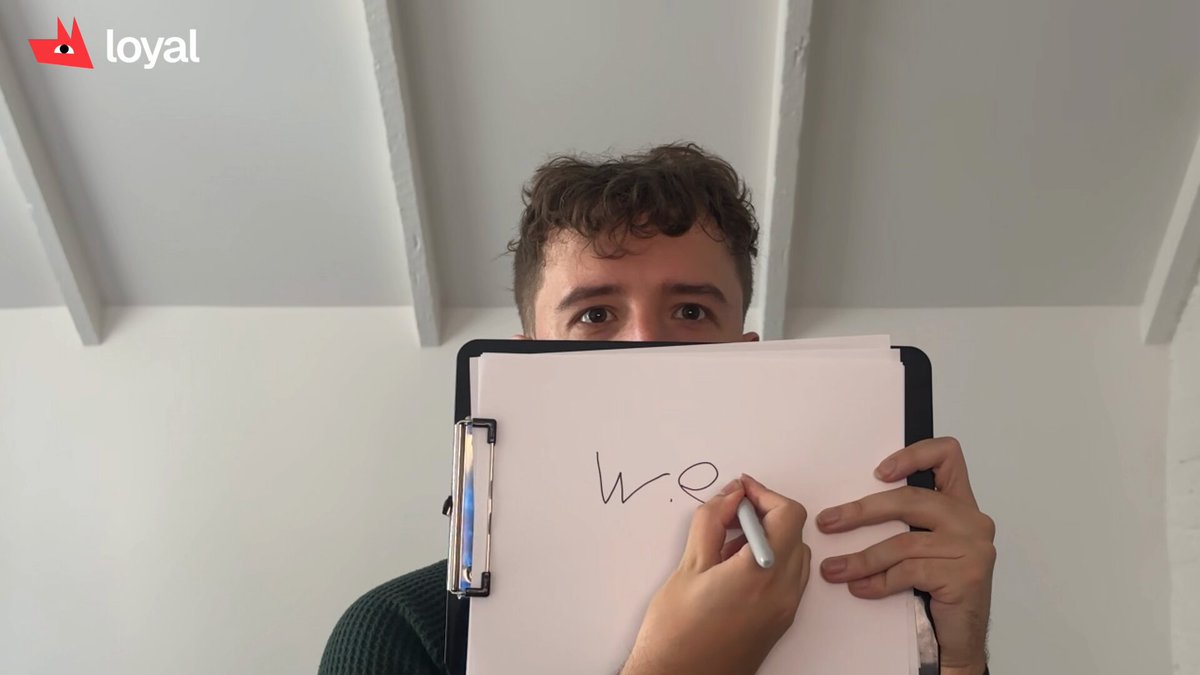 The image features a man holding up a piece of paper with the word "week" written on it. The text appears to be in black marker or ink, making it stand out against the white background. The man's face is partially obscured by the paper, and he seems to be looking directly at the camera. The post includes some text about an app called "earn ui", which might be related to the content of the image.