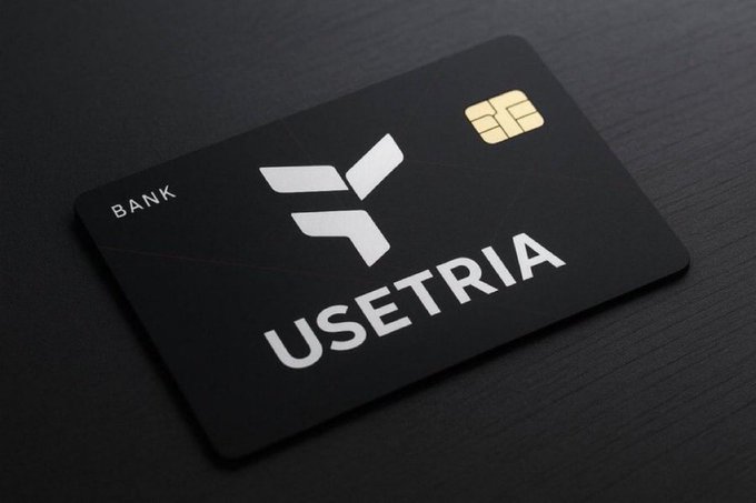 A black bank card mockup with a chip, labeled 'BANK' and 'USETRIA' with a silver geometric logo, displayed on a dark surface.