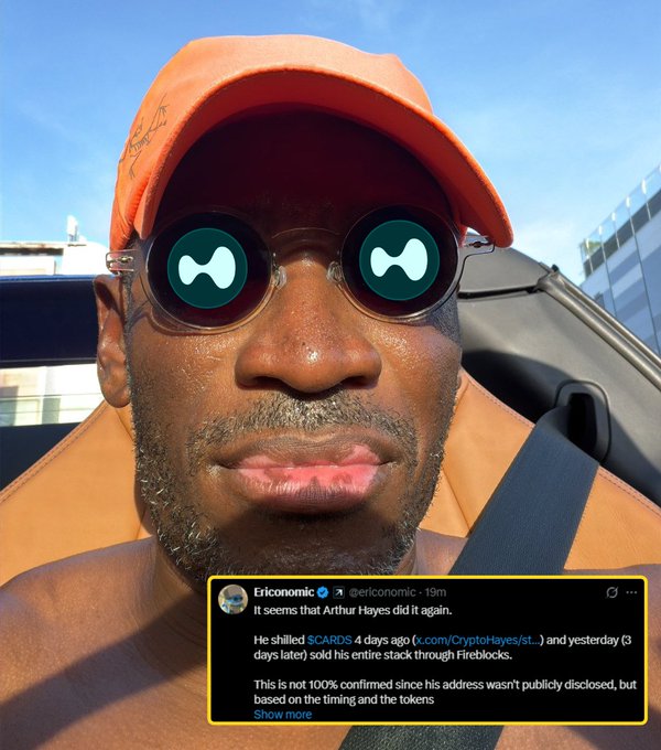 A man wearing an orange cap and sunglasses with a CARDANO (ADA) logo covers takes a selfie while driving, with a tweet from @ericonomic overlaid showing text about Arthur Hayes dumping his $SCARDS position, directly referencing the "Mr CARDman did it again" caption about a Cardano-related token selloff.