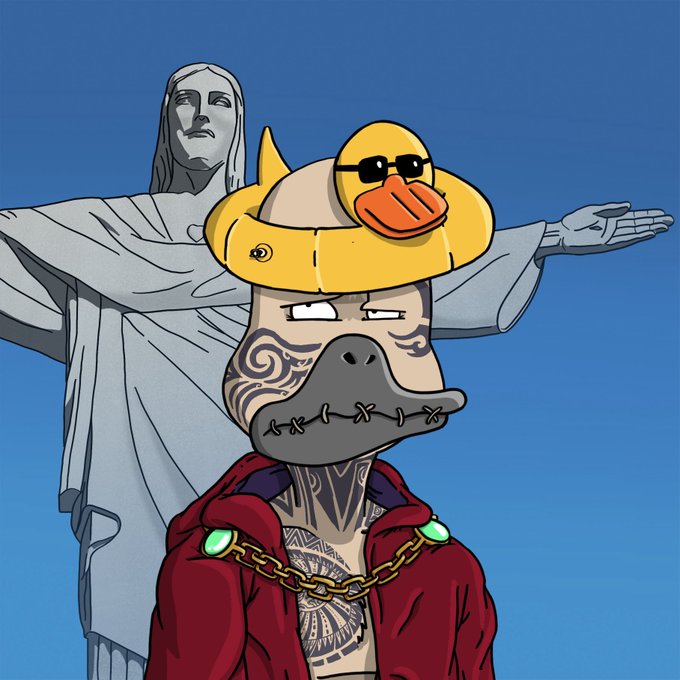 A cartoon illustration of a tattooed ape-like character wearing a red hoodie, gold chain, and a duck pool float on its head, positioned in front of the Christ the Redeemer statue in Rio de Janeiro.