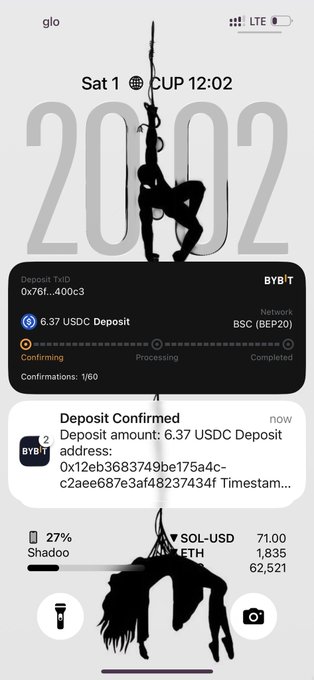 A smartphone home screen showing a wallpaper of a person climbing a rope, the time 12:02 on Saturday Oct 1, and a Bybit notification confirming a 6.37 USDC deposit on the BSC (BEP20) network.
