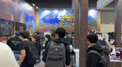 The image shows a large crowd of people gathered at an exhibition or convention center, standing around various booths and displays. The attendees are carrying backpacks and wearing t-shirts with logos like "@renaissxyz" and "@vinciwld". One person in particular is holding a backpack that has the logo "VINCI WLD" on it. The crowd appears to be engaged, possibly waiting for an event or participating in a special activity related to the Vinci World experience.
