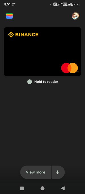 A mobile screen showing a black Binance payment card with the Mastercard logo and instructions to 'Hold to reader' using NFC.
