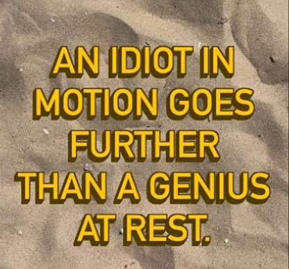 An inspirational quote displayed in bold yellow text on a sandy background reading: 'AN IDIOT IN MOTION GOES FURTHER THAN A GENIUS AT REST.'