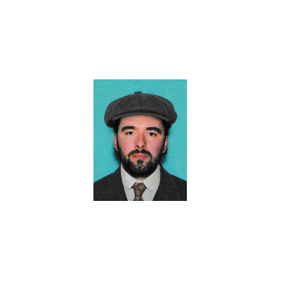Stylized portrait of a bearded man wearing a flat cap, suit, and patterned tie against a turquoise background.